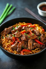 Delicious beef noodle soup with colorful vegetables served in a dark bowl on a textured surface
