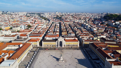 Uma imagem icónica do Terreiro do Paço (também conhecido como Praça do Comércio), situada na Baixa Pombalina, em Lisboa. A ampla praça está rodeada por majestosos edifícios de cor amarela com arcadas 