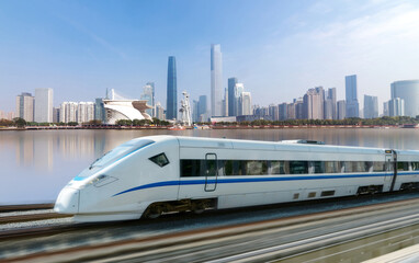 Naklejka premium High-speed rail speeds on Bridges and the modern city skyline of guangzhou, China