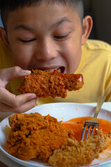 boy eating fried chicken.