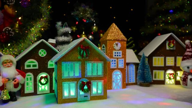 Against the backdrop of a Christmas wreath and fir trees, houses with a chapel and Santa Claus