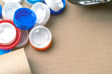 A pile of plastic caps on a brown surface. The caps are of different colors and sizes. Concept of...