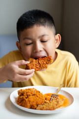 boy eating fried chicken.