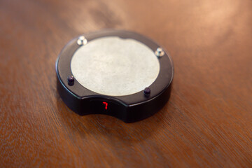 A small black object with a white circle on it with a red number 7 on it
