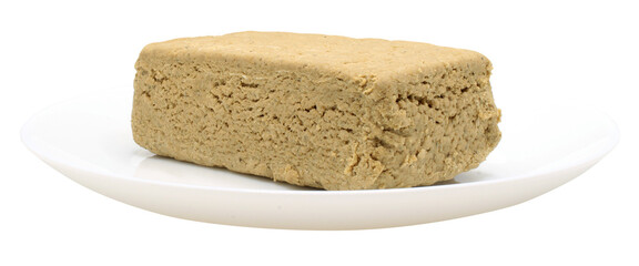 Sunflower halva in a white plate. Side view. Whole halvah. Food isolated on transparent background. Isolate on png format