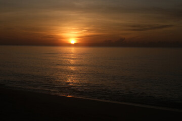 The sun rises at the sea in the morning.