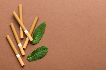 Menthol cigarettes and fresh mint leaves on colored background, Many cigarettes stacked together top view flat lay