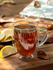 Cup of tea with lemon outdoors on wooden table