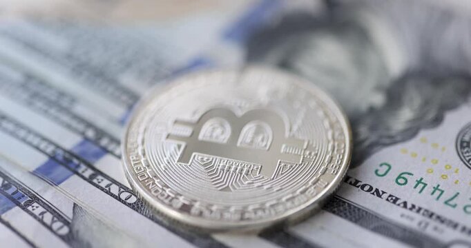Bitcoin coin lying on dollar bills 4k movie. Dollar investments in bitcoin cryptocurrency concept