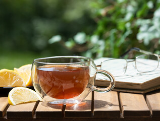Cup of tea and lenon slices on wooden table