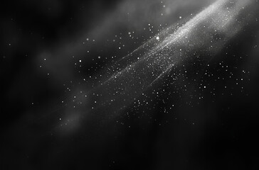 An abstract black background with white dust particles scattered across it, creating a subtle texture and sparkle effect.