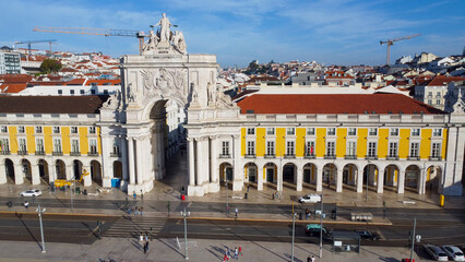 Obraz premium Uma imagem icónica do Terreiro do Paço (também conhecido como Praça do Comércio), situada na Baixa Pombalina, em Lisboa. A ampla praça está rodeada por majestosos edifícios de cor amarela com arcadas 