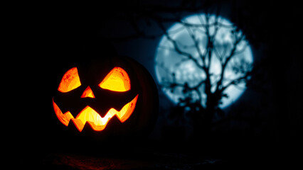 Fototapeta premium glowing jack-o'-lantern under a pale moon