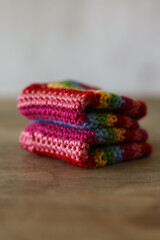Colorful crochet gloves on a wooden background. Handmade.