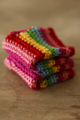 Colorful crochet gloves on a wooden background. Handmade.