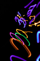 Light painting. Neon glow. Symmetry and reflection. Festive decoration. Abstract blurred background. Shining pattern.