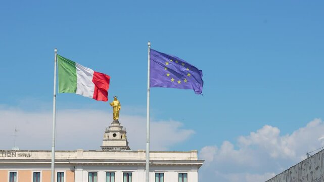 The flag of Italy and the flag of the European Union against the Statue of Christ the Redeemer atop the belltower of the Sacro Cuore di Ges&uacute; al Castro Pretorio