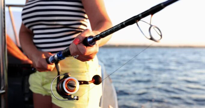 Fishing tackle and reels for fishing from boat in female hands. Fishing for tourists on vacation