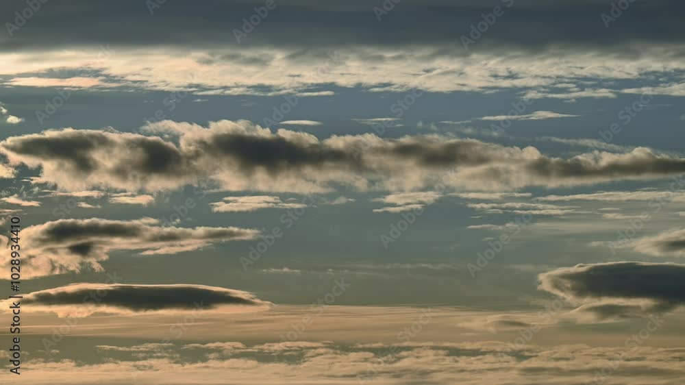 Wall mural time lapse early evening light blue sky with layers of clouds moving at different speeds