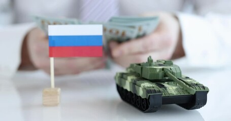 Russian flag and the tank in background counts dollars. Collapse and crisis of Russian economy after war concept - Powered by Adobe