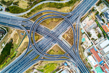 Aerial view of complex highway interchange surrounding lush greenery in daylight