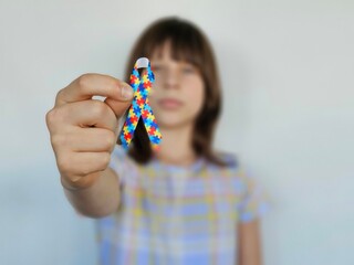 Teenager holding colorful ribbons raising awareness about autism.