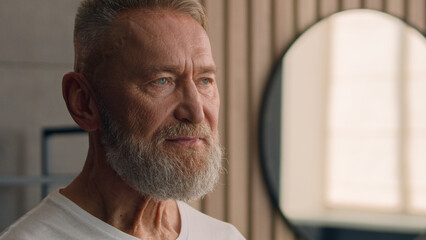 Portrait close up Caucasian retired generation health care senior mature male grandpa grandad indoors at home morning healthy old retire man in bath face bearded facial pensive dreaming thoughtful