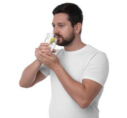 Fototapeta premium Handsome man drinking water with lemon on white background