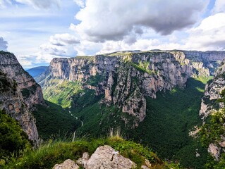 
Panoramic view over the steep and green cliffs of the Vikos Gorge in Epirus, Greece on a summer's day. The gorge in the Pindus Mountains is one of the deepest gorges in the world. Hiking in Greece