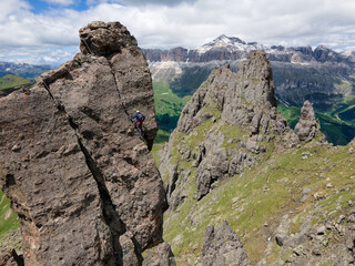 Via Ferrata delle Trincee, Dolomites, Val di Fassa Valley. Man climbing the vertical rocky mountain. Sella Group background (Pordoi, Piz Boè)