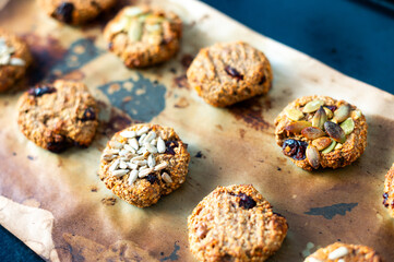 Homemade crispy oatmeal cookies with pumpkin and sunflower seeds on parchment paper. A healthy snack, perfect for a morning energy boost.