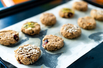 Homemade crispy oatmeal cookies with pumpkin and sunflower seeds on parchment paper. A healthy snack, perfect for a morning energy boost.