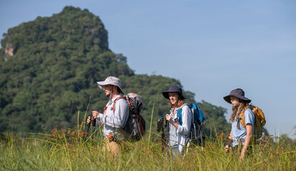 Family appears to be preparing for a hiking or camping expedition, as they are all equipped with...