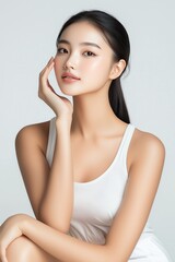 Fototapeta premium A stunning portrait of an elegant Asian female model showcasing natural beauty in a minimalist studio setting, radiating tranquility and grace.
