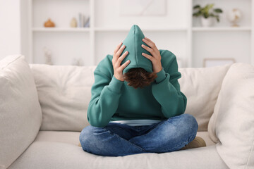 Obraz premium Loneliness concept. Sad teenage boy on sofa at home