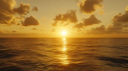 Obraz premium A breathtaking sunset over the ocean, with the sun sinking below the horizon, casting golden rays across the water. The sky is a vibrant mix of orange,