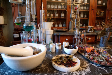 Chemistry flasks with liquids, herbs of medicinal plants in an old pharmacy
