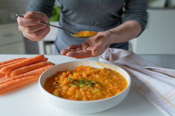 Woman serving bland food with easy to digest carrot potato soup in the kitchen