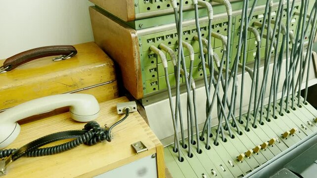 Close-up of an old analog telephone and switchboard used for connecting calls, showcasing vintage communication equipment. Concept of outdated technology and retro telecommunications systems