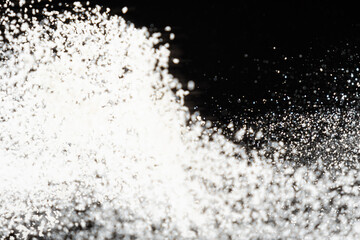 Abstract black and white background of pouring flour, space for text