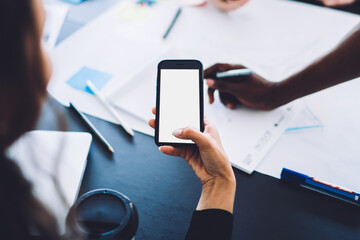 Woman taking photo of paper working with colleagues