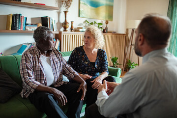 Senior couple having serious financial discussion with advisor at home