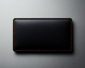 Black wallet with elegant stitching, set on a minimalistic gray background.