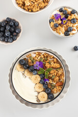 A healthy nutritious breakfast of natural Greek yoghurts, granola and fresh berries 