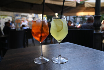 Verres d'alcool de différentes couleurs avec des pailles sur une table d'une terrasse de bar