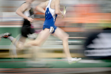 Naklejka premium Running a Relay Race on Track Holding Baton Team Effort and Competition