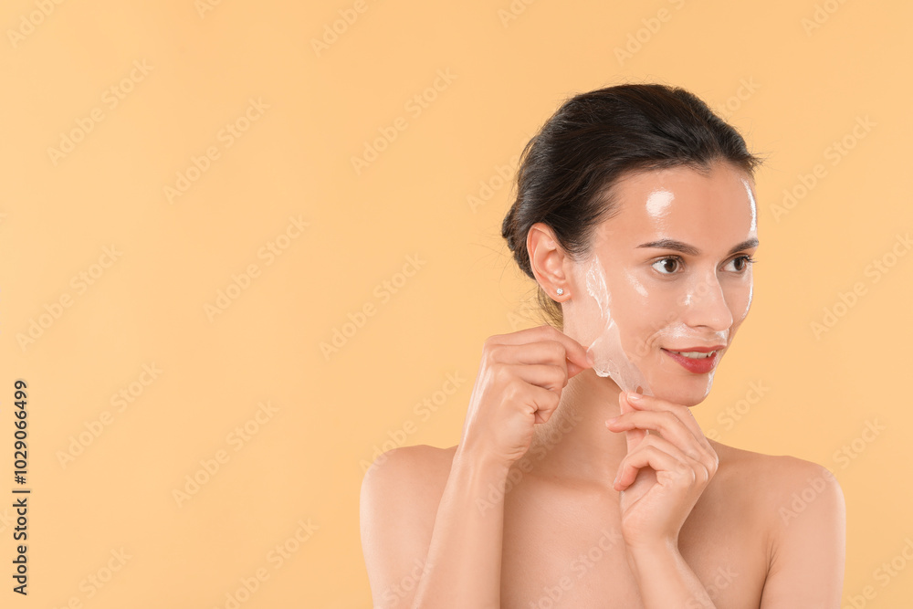 Canvas Prints Beautiful woman peeling off face mask on beige background. Space for text