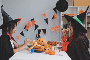 friendship, holiday and people concept - group of happy smiling friends in halloween costumes of vampire, devil, witch and cheetah at home party