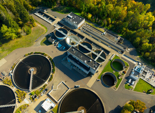 A view of a water treatment plant with several tanks and a large building