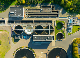 A view of a water treatment plant with four tanks and a large green area